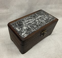 Item # TB-24 N  Hinged Lid wooden box with hand made metal pieces on the top and a latch on the front.  4'' x 6'' in size The Metal designs as well as color and the texture of the wood can vary some.